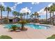 A dazzling community pool area featuring towering palm trees, lush landscaping, and a rock waterfall at 8250 N Grand Canyon Dr # 1084, Las Vegas, NV 89166