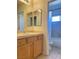 This bathroom features a vanity with double mirrors and a toilet and tub in the background at 8374 Pioneer Way, Las Vegas, NV 89113