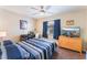 Comfortable bedroom with a ceiling fan, wooden dresser, a workstation and blue accents at 8455 W Sahara Ave # 287, Las Vegas, NV 89117