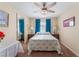Cozy bedroom with a floral-patterned bedspread, a ceiling fan, and bright blue curtains at 8455 W Sahara Ave # 287, Las Vegas, NV 89117