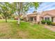 Serene backyard featuring lush green grass and mature trees with a view of the home's patio at 8513 Glenmount Dr, Las Vegas, NV 89134