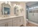 Bright bathroom featuring double sinks, white cabinetry and a glass-enclosed shower at 8513 Glenmount Dr, Las Vegas, NV 89134
