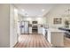 Bright modern kitchen with white cabinets, stainless steel appliances, and open concept to dining area at 8513 Glenmount Dr, Las Vegas, NV 89134