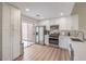 Bright modern kitchen with white cabinets, stainless steel appliances, and sliding door to backyard at 8513 Glenmount Dr, Las Vegas, NV 89134