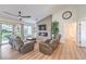 Living room with modern fireplace, wood floors, ceiling fan, and backyard access at 8513 Glenmount Dr, Las Vegas, NV 89134