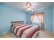 Bright bedroom featuring a light color palette, a ceiling fan, and a large window at 8861 Hampton Green Ave, Las Vegas, NV 89129