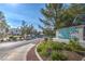 Community entrance sign showcasing lush landscaping, trees and paved walking path at 8861 Hampton Green Ave, Las Vegas, NV 89129