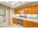 Traditional kitchen with wooden cabinets, white countertops, and modern appliances at 8861 Hampton Green Ave, Las Vegas, NV 89129