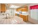 Well-lit kitchen featuring white tile countertops and light wood cabinets at 8861 Hampton Green Ave, Las Vegas, NV 89129