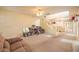 Bright living room with beige carpet, ceiling fan, and staircase to the second level at 8861 Hampton Green Ave, Las Vegas, NV 89129