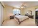 Neutral bedroom featuring a ceiling fan, mirrored furniture set and an accent pillow reading 