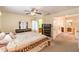 Neutral primary bedroom featuring a ceiling fan, mirrored furniture and an ensuite bathroom at 8861 Hampton Green Ave, Las Vegas, NV 89129