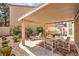 Outdoor patio area with covered seating, a lounge chair, and lush landscaping at 8861 Hampton Green Ave, Las Vegas, NV 89129