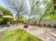 Backyard featuring a fire pit, artificial grass, desert landscaping and outdoor seating at 9037 Picket Fence Ave, Las Vegas, NV 89143