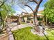 Spacious backyard featuring artificial grass, mature trees, and a pergola seating area at 9037 Picket Fence Ave, Las Vegas, NV 89143