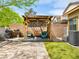 Backyard with covered patio, artificial grass, pergola and outdoor seating at 9037 Picket Fence Ave, Las Vegas, NV 89143