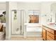Bathroom with tiled floors, separate tub, shower, and window with natural light at 9037 Picket Fence Ave, Las Vegas, NV 89143