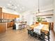 Open-concept kitchen and dining area with wood floors, cabinets, and stainless steel appliances at 9037 Picket Fence Ave, Las Vegas, NV 89143