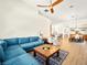 Open living area with a blue sofa, a wood-topped coffee table, and view of the dining space at 9037 Picket Fence Ave, Las Vegas, NV 89143
