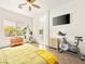 Bright main bedroom features wood floors, a ceiling fan, TV, and a sunny window at 9037 Picket Fence Ave, Las Vegas, NV 89143