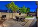 Outdoor space featuring a well-kept artificial lawn, mature trees, and seating at 9413 Artesian Oak Ct, Las Vegas, NV 89149
