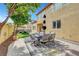 Outdoor living space with a dining set and serene views of the landscaped yard at 9413 Artesian Oak Ct, Las Vegas, NV 89149