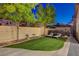 Lush backyard with manicured lawn, mature trees, and comfortable lounge chairs at 9413 Artesian Oak Ct, Las Vegas, NV 89149