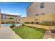 Serene backyard with a rock waterfall feature flowing into a pool, bordered by lush greenery at 9413 Artesian Oak Ct, Las Vegas, NV 89149
