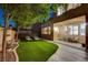 Picturesque backyard featuring a well-manicured lawn, shaded trees, and cozy seating area at 9413 Artesian Oak Ct, Las Vegas, NV 89149