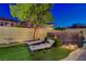 Lush backyard featuring a well-manicured lawn, shade trees, and lounge chairs for relaxation at 9413 Artesian Oak Ct, Las Vegas, NV 89149