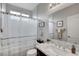 This bathroom features tile walls and a framed mirror above a dark wood vanity at 9413 Artesian Oak Ct, Las Vegas, NV 89149