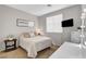 A cozy bedroom with a queen sized bed and a vanity with lights at 9413 Artesian Oak Ct, Las Vegas, NV 89149