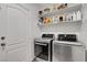 Convenient laundry room equipped with modern washer and dryer, and practical shelving for easy organization at 9413 Artesian Oak Ct, Las Vegas, NV 89149