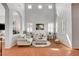 Bright living room with tall ceilings, tile floors, arched openings, plantation shutters, and comfortable neutral-colored furniture at 9413 Artesian Oak Ct, Las Vegas, NV 89149