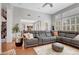 Living room with tiled flooring, large gray couch, stairs, and open concept at 9413 Artesian Oak Ct, Las Vegas, NV 89149