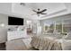 A spacious main bedroom featuring a ceiling fan, seating area, natural light, and an adjoining bathroom at 9413 Artesian Oak Ct, Las Vegas, NV 89149
