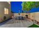 Outdoor dining area with a grill, landscaped yard, and beautiful evening ambiance at 9413 Artesian Oak Ct, Las Vegas, NV 89149
