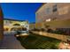 Beautiful pool with waterfall feature surrounded by lush landscaping and evening lighting at 9413 Artesian Oak Ct, Las Vegas, NV 89149