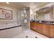 Elegant bathroom features a glass shower, soaking tub with black countertop, and double sink vanity at 135 E Harmon Ave # 3217, Las Vegas, NV 89109