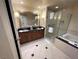 Bright bathroom features a double sink vanity, glass shower, and soaking tub with black countertops at 135 E Harmon Ave # 3217, Las Vegas, NV 89109