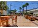 Relaxing outdoor seating area with comfortable wooden furniture, string lights, and palm trees under a clear sky at 135 E Harmon Ave # 3217, Las Vegas, NV 89109