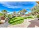 Lush backyard with artificial turf, beautiful landscaping, and privacy, perfect for outdoor living and entertaining at 14 Hunt Valley Trl, Henderson, NV 89052