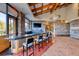 Modern bar area with dark countertop, stylish stools, stone accents, and a large television at 14 Hunt Valley Trl, Henderson, NV 89052