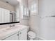 Bright bathroom featuring white cabinets, tile flooring, and a glass shower enclosure at 14 Hunt Valley Trl, Henderson, NV 89052