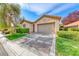 Charming single-story home with a well-manicured lawn, mature tree, and a two-car garage at 14 Hunt Valley Trl, Henderson, NV 89052