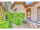 Charming front yard featuring mature landscaping, a walkway and an arched gate leading to the front door at 14 Hunt Valley Trl, Henderson, NV 89052