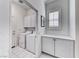 Laundry room featuring a washer, dryer, storage cabinets, and tile flooring at 14 Hunt Valley Trl, Henderson, NV 89052