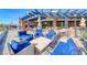 Outdoor patio with comfortable seating, umbrellas for shade, and views of the surrounding landscape at 14 Hunt Valley Trl, Henderson, NV 89052