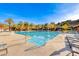 Large swimming pool surrounded by lounge chairs and palm trees for a resort-like experience at 14 Hunt Valley Trl, Henderson, NV 89052