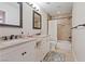 Bathroom featuring double sinks, granite countertops, decorative mirrors, and a shower with a curtain at 1508 Sun Copper Dr, Las Vegas, NV 89117